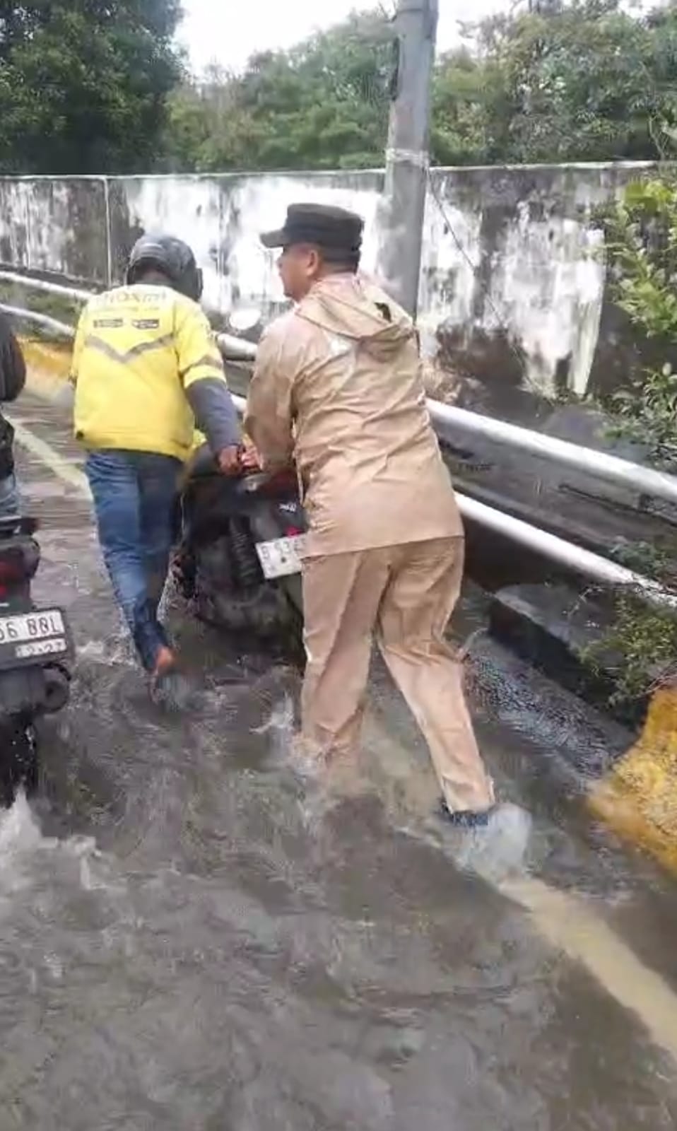 Polisi Bantu Pengendara Ditengah Genangan Air Satria Raya